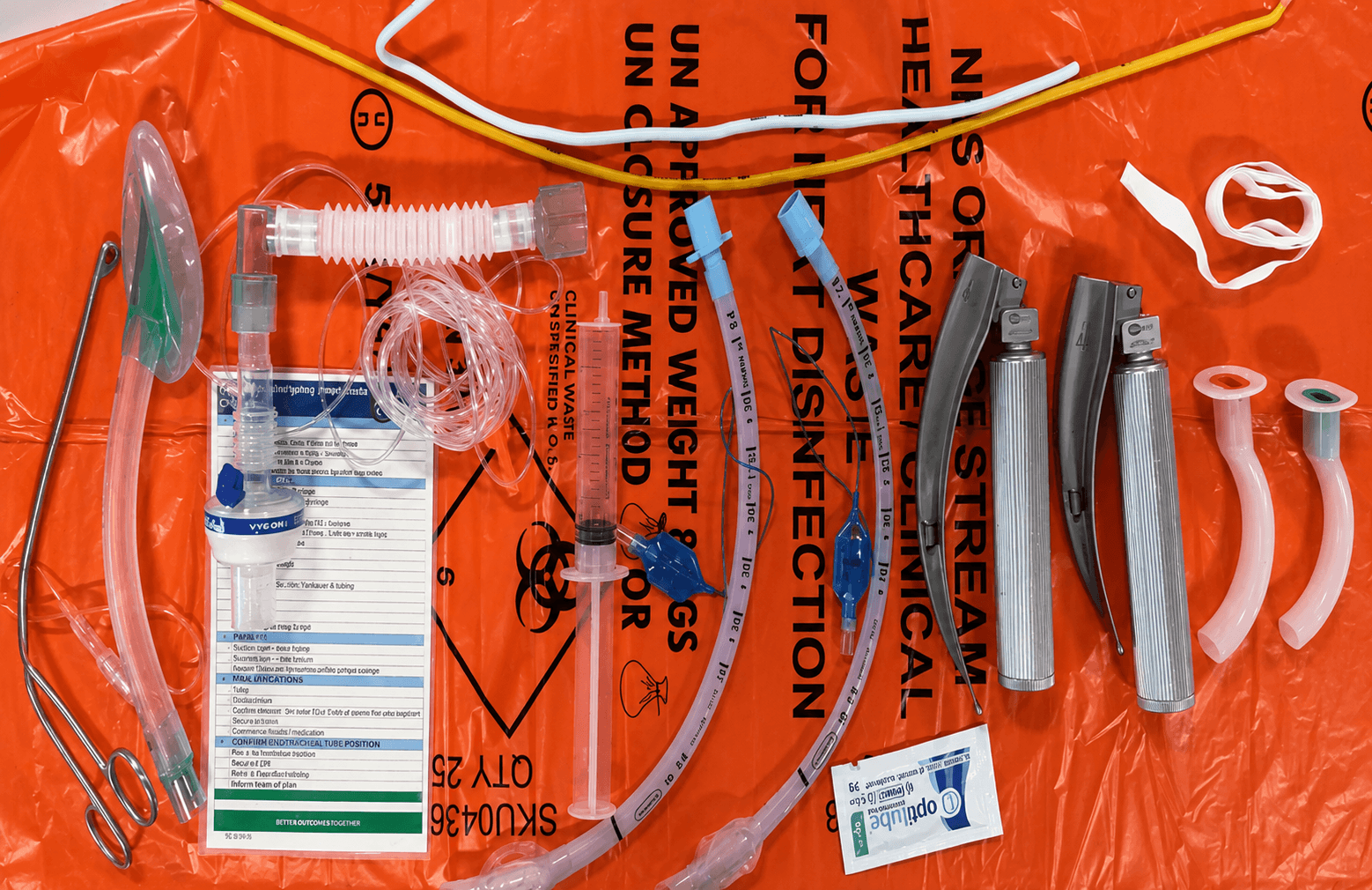 Emergency airway equipment laid out on a clinical waste bag as a kit dump